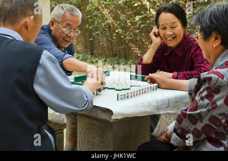 Xi'an, Chine - 2011, 15 mai : un groupe de personnes âgées amis jouer mahjong dans leur jardin. Banque D'Images