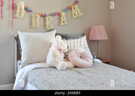 Chambre d'enfant moderne à la poupée et les oreillers sur le lit Banque D'Images