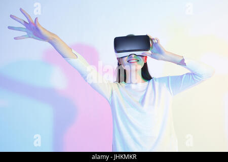 Jeune femme à l'aide de casque de réalité virtuelle Banque D'Images