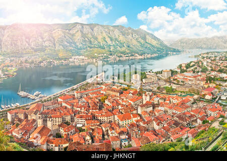 Vue de la baie de Kotor avec soleil brille sur les montagnes sur le vieux toit en tuiles rouges, Kotor, Monténégro bâtiments Banque D'Images