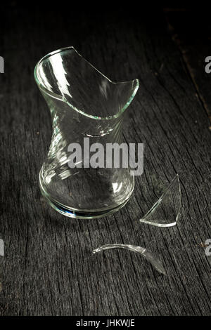 Des éclats de verre et de verre cassée sur un fond de bois gris. Clé faible. Banque D'Images