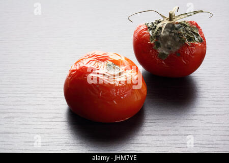 Les tomates pourries sur fond de bois Banque D'Images