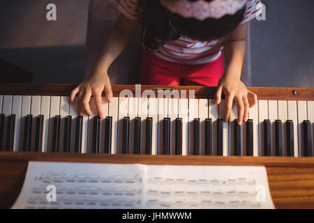 Vue de dessus de girl practicing piano en classe à l'école de musique Banque D'Images