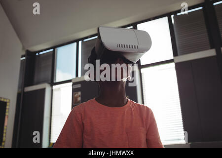 Low angle view of boy wearing simulateur de réalité virtuelle en classe Banque D'Images
