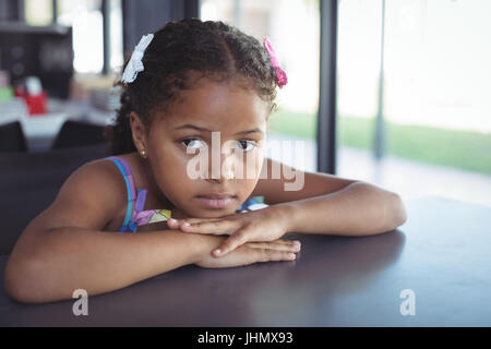 Close up portrait of girl leaning on desk in school Banque D'Images