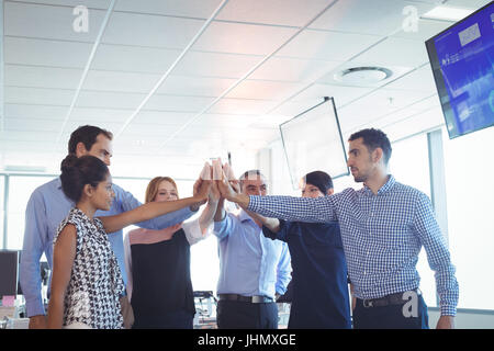 Des collègues mettent leurs mains ensemble at office Banque D'Images