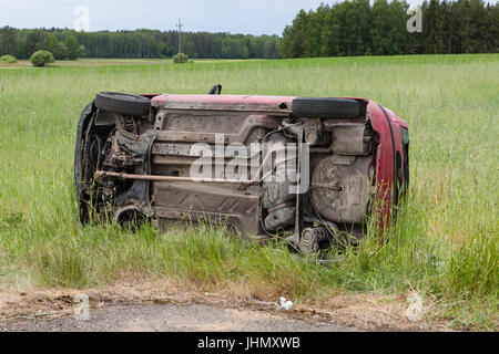 Carcasse de voiture couchée sur le côté dans un champ de céréales Banque D'Images