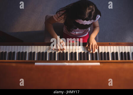 Vue aérienne de l'enseignement élémentaire girl playing piano en classe à l'école de musique Banque D'Images