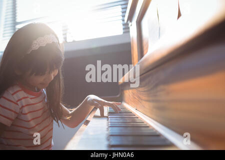 Girl practicing élémentaire en classe de piano à l'école de musique Banque D'Images