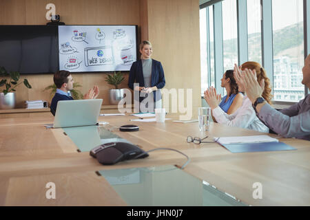 Collègues clapping lors du meeting en salle du conseil d'administration Banque D'Images