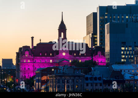 Montréal, Canada. 13 juillet 2017. L'Hôtel de Ville de Montréal illuminée en mauve au coucher du soleil Banque D'Images