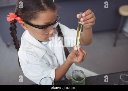 High angle viewof élève d'école élémentaire l'examen chimique jaune en tube à essai au laboratoire scientifique. Banque D'Images