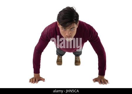 Portrait of young businessman doing push ups contre fond blanc Banque D'Images