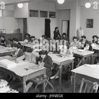 1948, historique, l'Angleterre, l'image montre les filles dans une classe de couture à un collège de formation des enseignants, avec un enseignant de superviser un étudiant en utilisant une machine à coudre. Banque D'Images