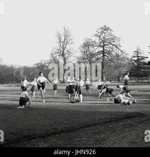 Années 1950, l'Angleterre, les étudiantes à un collège de formation des enseignants ne PE ou les exercices physiques à l'extérieur dans le colege avec quelques motifs, à l'aide de cerceaux. Banque D'Images