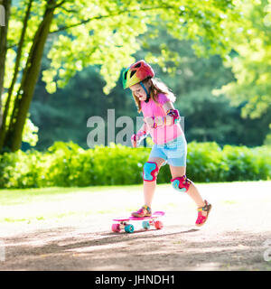 Child riding skateboard park en été. Petite fille à apprendre à faire du vélo skate board. Sport actif à l'extérieur pour l'école et le jardin d'enfants. Enfants skat Banque D'Images