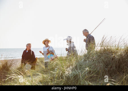 Les couples avec canne à pêche randonnée pédestre à sunny beach grass Banque D'Images