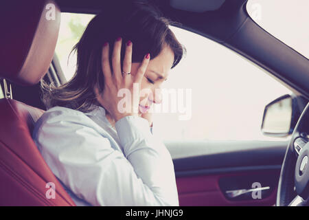 Souligné femme assis à l'intérieur sa voiture Banque D'Images