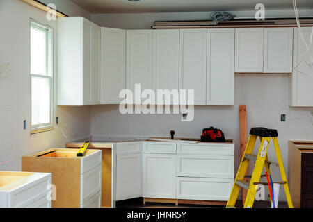 Armoires de cuisine sur mesure à diverses étapes de base pour l'installation dans l'île d'installation du centre d'armoires de cuisine Banque D'Images