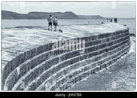 Visiteurs sur le Cobb à Lyme Regis, dans le Dorset en Juillet - noir et blanc monochrome fine art Banque D'Images