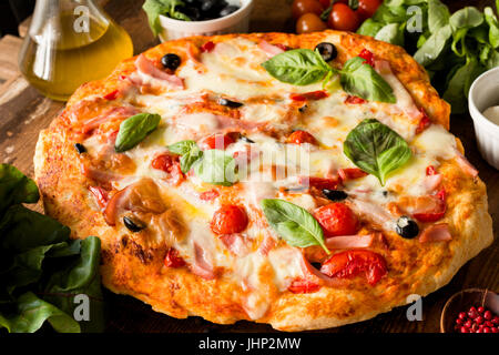 Pizza italienne maison de fromage mozzarella, tomates, olives noires et des feuilles de basilic. Vue rapprochée Banque D'Images