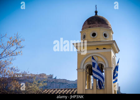 Église orthodoxe grecque détail avec des drapeaux grecs et de l'Acropole et le Parthénon en arrière-plan. Voir à partir de la place Monastiraki à Athènes Banque D'Images