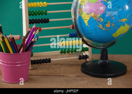 Close-up du monde entier, porte-plume et abacus sur table en bois Banque D'Images