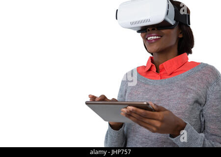 Femme portant des lunettes vr lors de l'utilisation de tablet computer against white background Banque D'Images