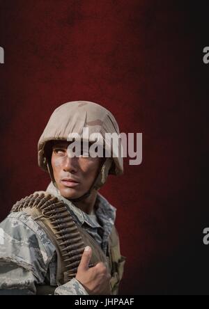 Digital composite de soldat homme debout contre un arrière-plan rouge Banque D'Images