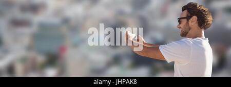 Digital composite de l'homme en chemise blanche contre selfies ville floue Banque D'Images