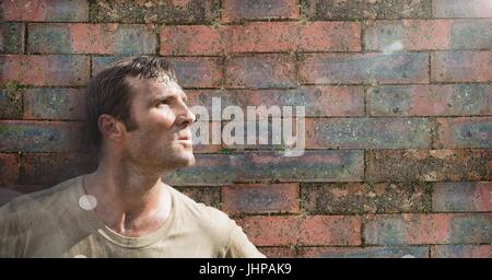 Digital composite de soldat homme debout contre le mur de brique Banque D'Images