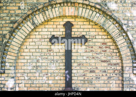 Vieille croix de métal sur fond de mur de briques - Rusty tombe sur la croix Banque D'Images