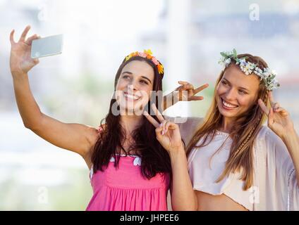 Composite numérique des femmes prenant photo selfies occasionnels en face d'arrière-plan flou Banque D'Images