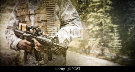 Road through forest contre soldier un fusil militaire Banque D'Images