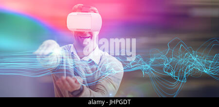 Happy man gesturing lors de l'utilisation de lunettes de réalité virtuelle contre lignes rougeoyant futuriste sur fond noir Banque D'Images