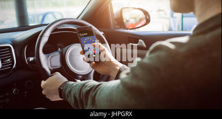 L'homme en regardant le GPS sur son téléphone dans sa voiture Banque D'Images