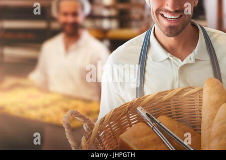 Baker holding en pain panier moustaches contre portrait of female baker smiling Banque D'Images