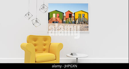 Fauteuil jaune par contre table cadre photo Blanc contre multi colored abris sur le sable contre ciel clair Banque D'Images