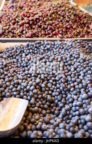 Abondance de cerises rouges et les bleuets fraîchement cueillis à la vente à un marché de producteurs locaux Banque D'Images