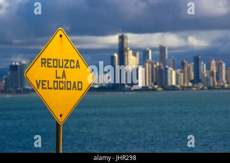 Road sign reading reduzca la vitesse avec la ville de Panama à l'arrière-plan Banque D'Images