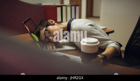Fatigué businesswoman leaning on desk in office Banque D'Images