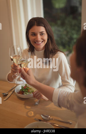 Smiling couple toasting verres de vin à la maison à la maison Banque D'Images