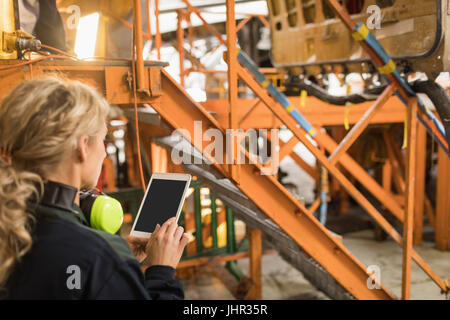 Technicien d'entretien d'une femme à l'aide de tablette numérique à l'installation de maintenance des compagnies aériennes Banque D'Images