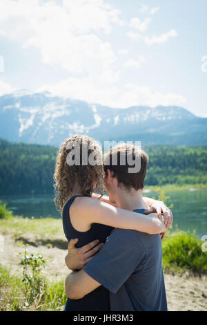 Couple de câliner les uns les autres près d'un lac à la campagne Banque D'Images