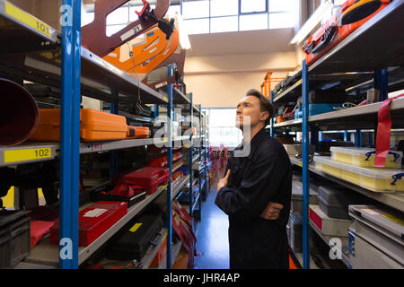 Homme technicien d'entretien d'aéronef l'examen de divers outil de travail à l'installation de maintenance des compagnies aériennes Banque D'Images