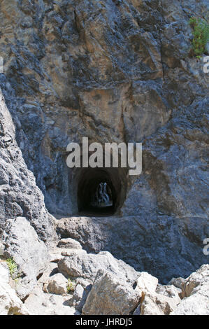 Italie : tunnel creusé dans la roche qui mène à la plage cachée, Arco Magno little bay avec une arche naturelle faite par les vagues au cours des siècles Banque D'Images