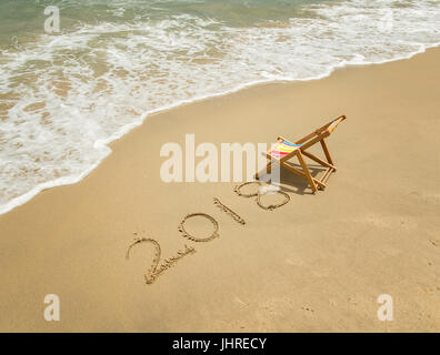 Chaise longue avec 2018 écrit dans le sable écrire on tropical beach. Banque D'Images