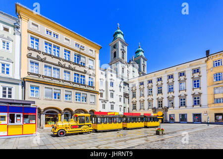 Linz, Autriche. Ancienne Cathédrale (Alter Dom) et train touristique sur la place principale (Hauptplatz) Banque D'Images