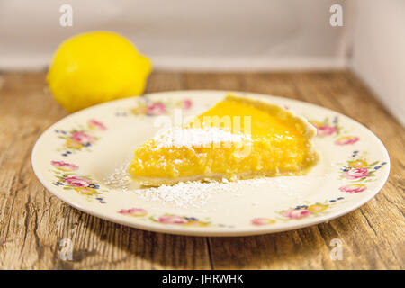 Tranche de tarte au citron isolé sur un fond de bois. Profondeur de champ Banque D'Images