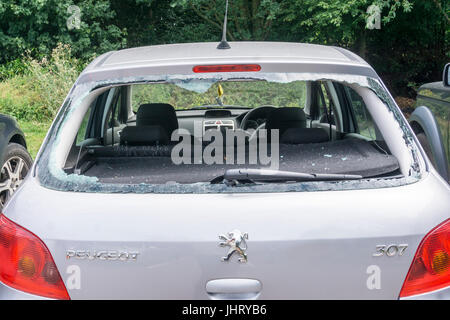 La fenêtre arrière cassée d'une voiture dans un parking. Banque D'Images